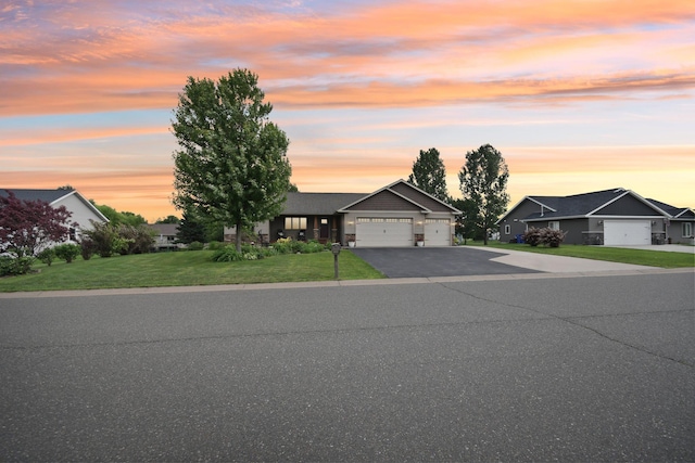 106 Prairie Grass Dr, Osceola, WI 54020 - view of front of house with a garage, asphalt driveway, and a yard