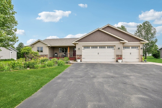 106 Prairie Grass Dr, Osceola, WI 54020 - craftsman house featuring stone siding, a front yard, driveway, and a garage