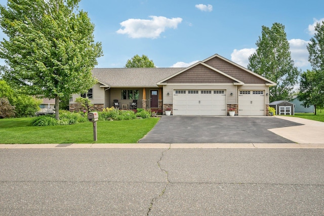 106 Prairie Grass Dr, Osceola, WI 54020 - view of front of property with stone siding, driveway, a front lawn, and a garage