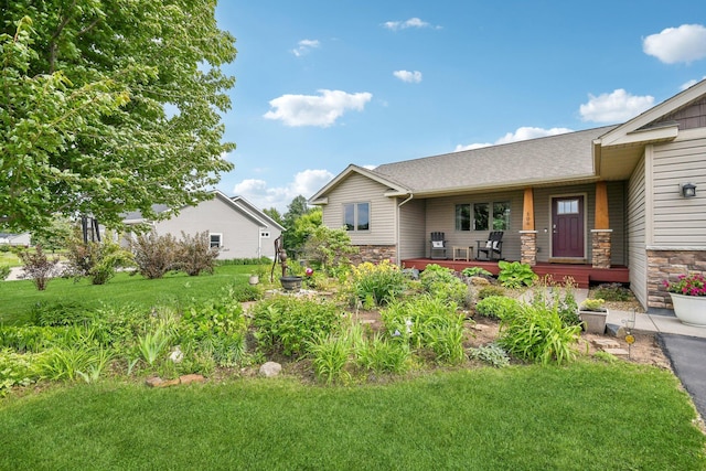 106 Prairie Grass Dr, Osceola, WI 54020 - view of front of property featuring stone siding, covered porch, a front lawn, and roof with shingles