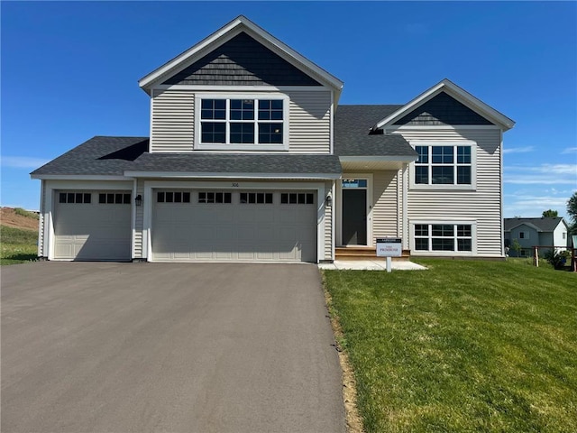306 Cypress St, Somerset, WI 54025 - view of front of property featuring a front lawn, a shingled roof, asphalt driveway, and an attached garage