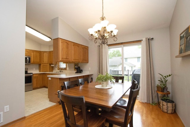 2109 Haughton Ave, North Mankato, MN 56003 - dining room featuring light wood-style floors, a chandelier, and vaulted ceiling