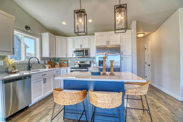 6242 87th Ave S, Horace, ND 58047 - kitchen with appliances with stainless steel finishes, backsplash, a sink, a breakfast bar, and dark wood finished floors