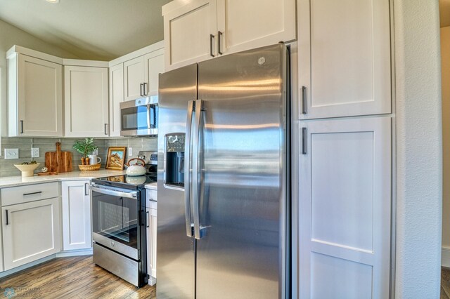 6242 87th Ave S, Horace, ND 58047 - kitchen featuring stainless steel appliances, white cabinetry, wood finished floors, decorative backsplash, and lofted ceiling