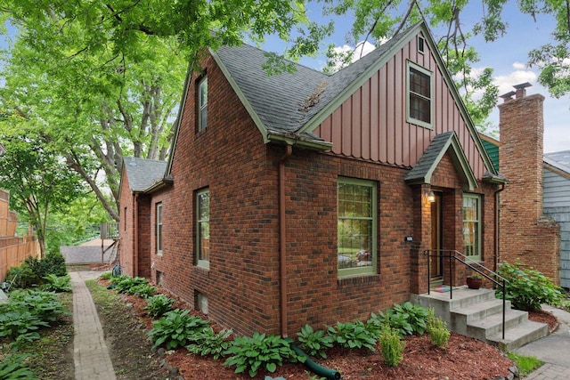 3527 Queen Ave N, Minneapolis, MN 55412 - view of front facade with board and batten siding, a shingled roof, and brick siding