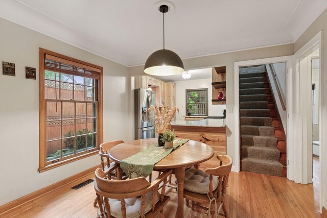 3527 Queen Ave N, Minneapolis, MN 55412 - dining room featuring stairway, light wood-type flooring, healthy amount of natural light, and crown molding