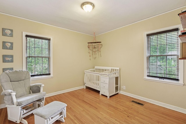 3527 Queen Ave N, Minneapolis, MN 55412 - bedroom with crown molding, multiple windows, and light wood-type flooring
