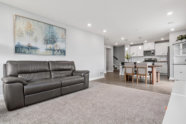 7243 Fall Dr, Lino Lakes, MN 55038 - living room with recessed lighting, stairway, light wood-style flooring, and light carpet