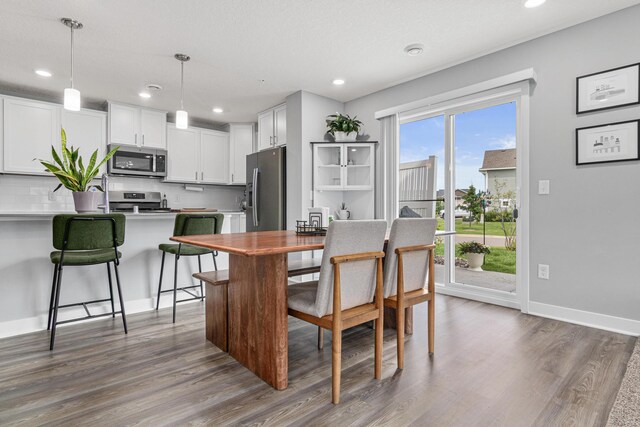 7243 Fall Dr, Lino Lakes, MN 55038 - kitchen with stainless steel appliances, tasteful backsplash, dark wood-type flooring, white cabinets, and recessed lighting