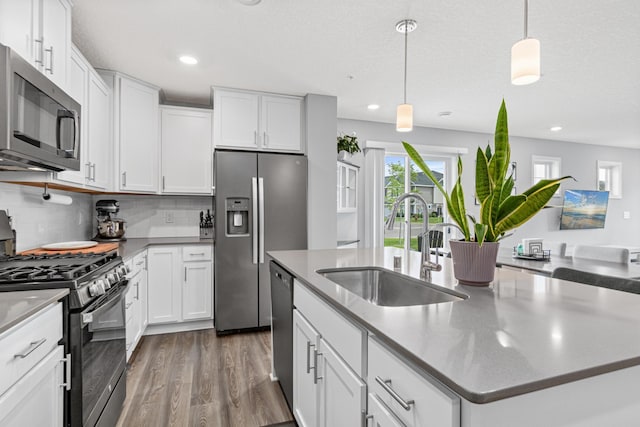 7243 Fall Dr, Lino Lakes, MN 55038 - kitchen featuring stainless steel appliances, a center island with sink, dark wood-style floors, white cabinetry, and recessed lighting