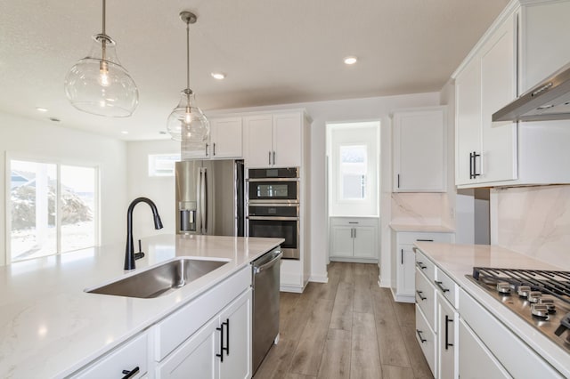11444 Fieldstone Dr, Rogers, MN 55311 - kitchen featuring a sink, stainless steel appliances, white cabinets, decorative light fixtures, and recessed lighting