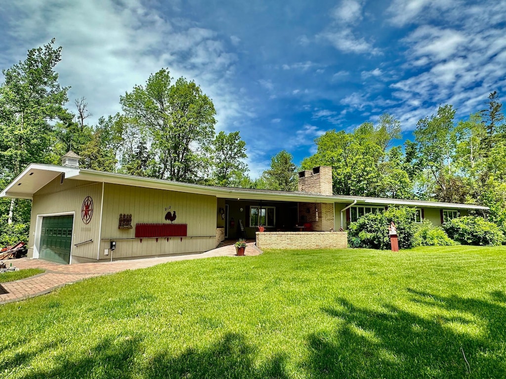 912 Central Ave W, Greenbush, MN 56726 - view of front facade with a chimney, a front yard, and a garage
