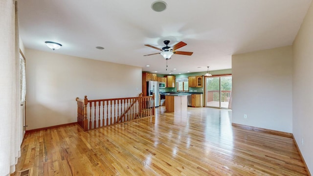 1364 Lone Stone Ct SE, Chatfield, MN 55923 - unfurnished living room featuring light wood-style flooring, ceiling fan, and baseboards