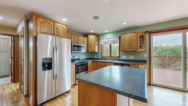 1364 Lone Stone Ct SE, Chatfield, MN 55923 - kitchen featuring stainless steel appliances, a sink, dark countertops, light wood-type flooring, and a center island