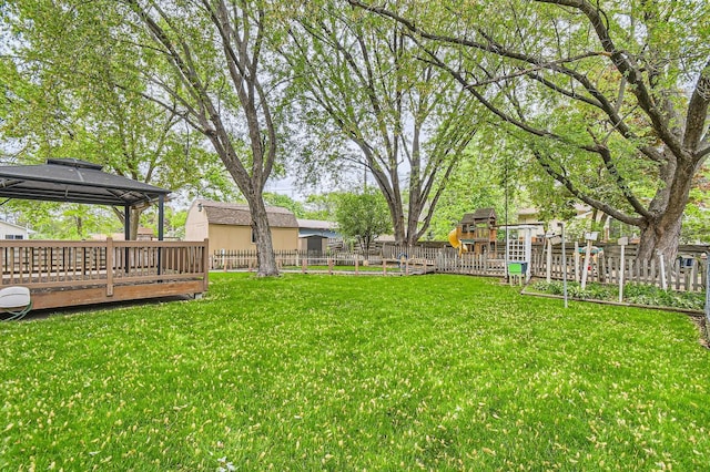 view of yard featuring a gazebo, a playground, and a wooden deck