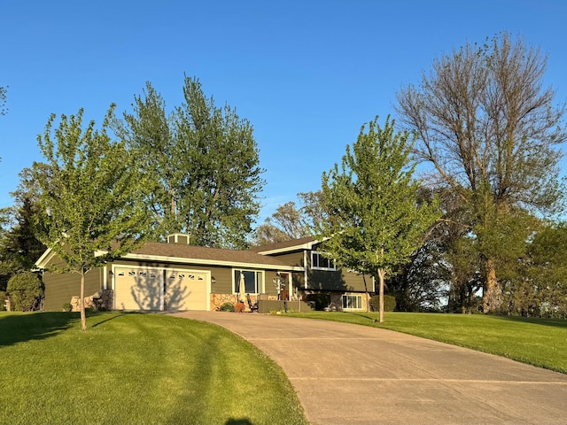 701 Mill St, Fertile, MN 56540 - split level home featuring an attached garage, concrete driveway, stone siding, and a front lawn