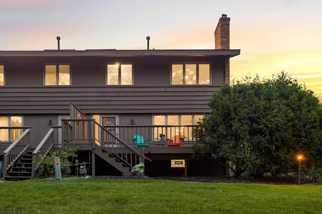 123 Windsor Ct, New Brighton, MN 55112 - back of property at dusk with stairway, a lawn, a wooden deck, and a chimney
