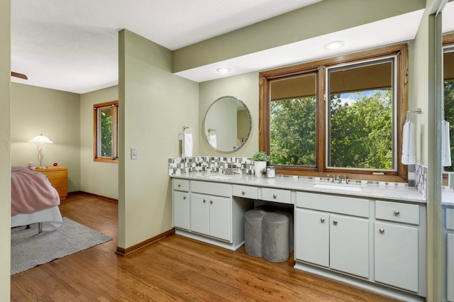 123 Windsor Ct, New Brighton, MN 55112 - full bathroom with double vanity, wood finished floors, and baseboards