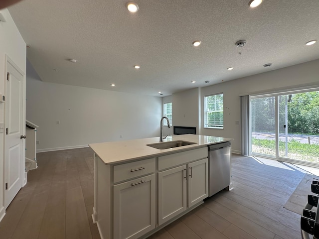 20025 62nd Pl, Corcoran, MN 55340 - kitchen featuring stainless steel dishwasher, a sink, a textured ceiling, a kitchen island with sink, and hardwood / wood-style floors