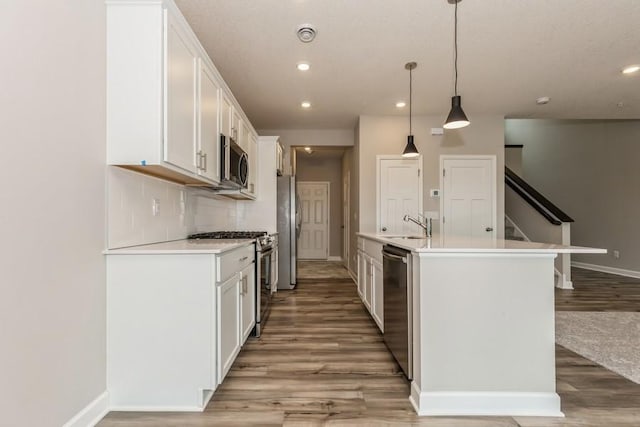 20025 62nd Pl, Corcoran, MN 55340 - kitchen featuring stainless steel appliances, light wood-type flooring, tasteful backsplash, white cabinetry, and baseboards