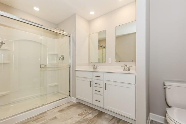 20025 62nd Pl, Corcoran, MN 55340 - bathroom with toilet, a stall shower, wood finished floors, double vanity, and recessed lighting