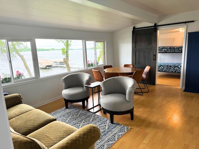 16263 Amelia Rd, Glenwood Twp, MN 56334 - living room featuring a barn door, light wood-style floors, a water view, and wooden walls