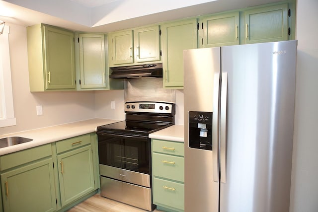 213 Lake Ave, Detroit Lakes, MN 56501 - kitchen with stainless steel appliances, under cabinet range hood, green cabinets, and light countertops