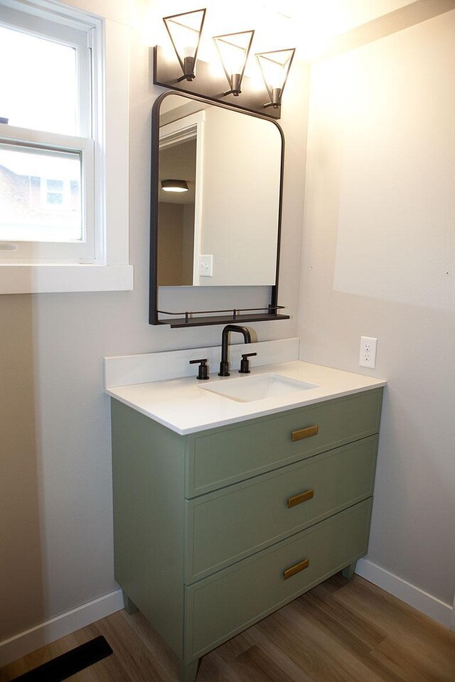 213 Lake Ave, Detroit Lakes, MN 56501 - bathroom featuring vanity, wood finished floors, and baseboards