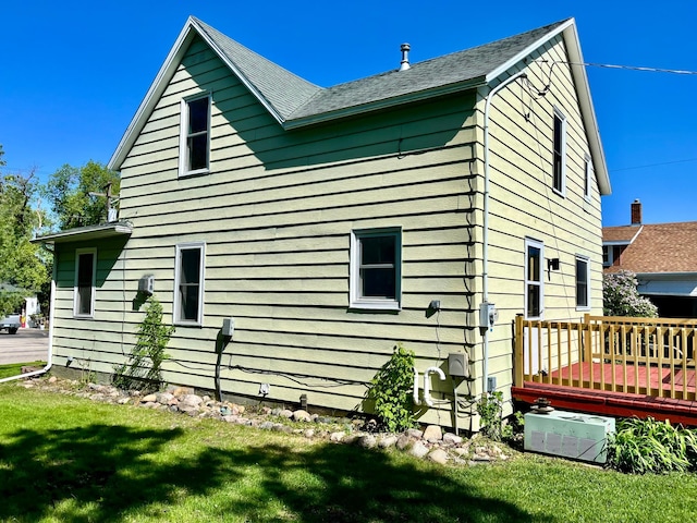 213 Lake Ave, Detroit Lakes, MN 56501 - view of property exterior with a deck, a lawn, ac unit, and a shingled roof