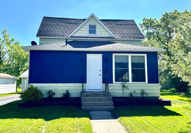 213 Lake Ave, Detroit Lakes, MN 56501 - bungalow featuring entry steps, a front yard, and a shingled roof