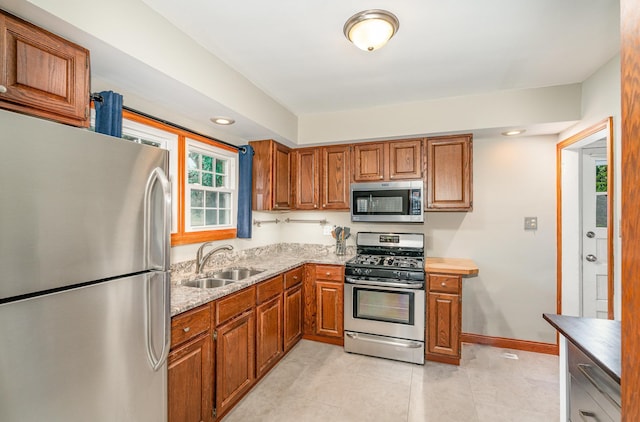 5805 Sunrise Dr, Minneapolis, MN 55419 - kitchen with appliances with stainless steel finishes, brown cabinetry, light tile patterned flooring, light stone counters, and recessed lighting