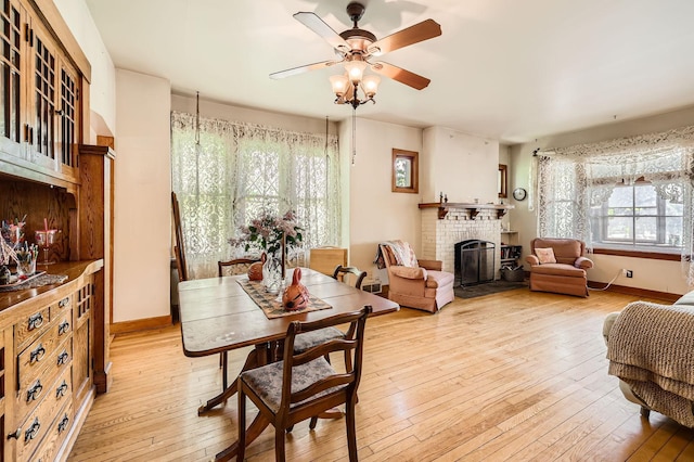 1107 Edmund Ave, Saint Paul, MN 55104 - dining space featuring light wood finished floors, a ceiling fan, and a brick fireplace