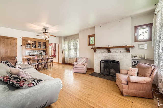 1107 Edmund Ave, Saint Paul, MN 55104 - living room featuring ceiling fan, a brick fireplace, healthy amount of natural light, and light wood-style flooring
