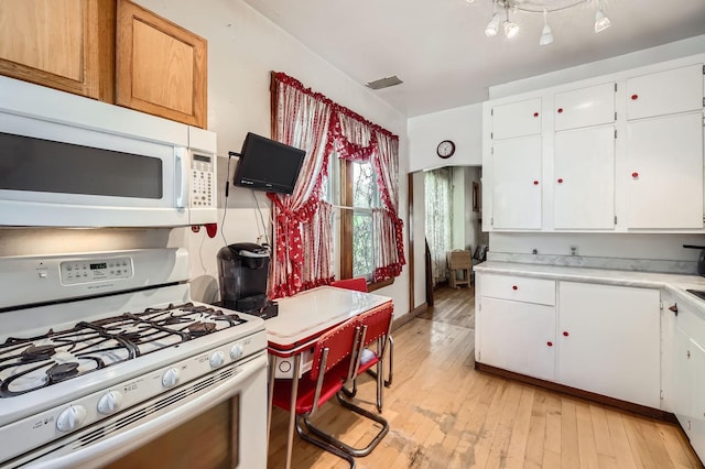 1107 Edmund Ave, Saint Paul, MN 55104 - kitchen with white appliances, light countertops, light wood-style floors, and white cabinets
