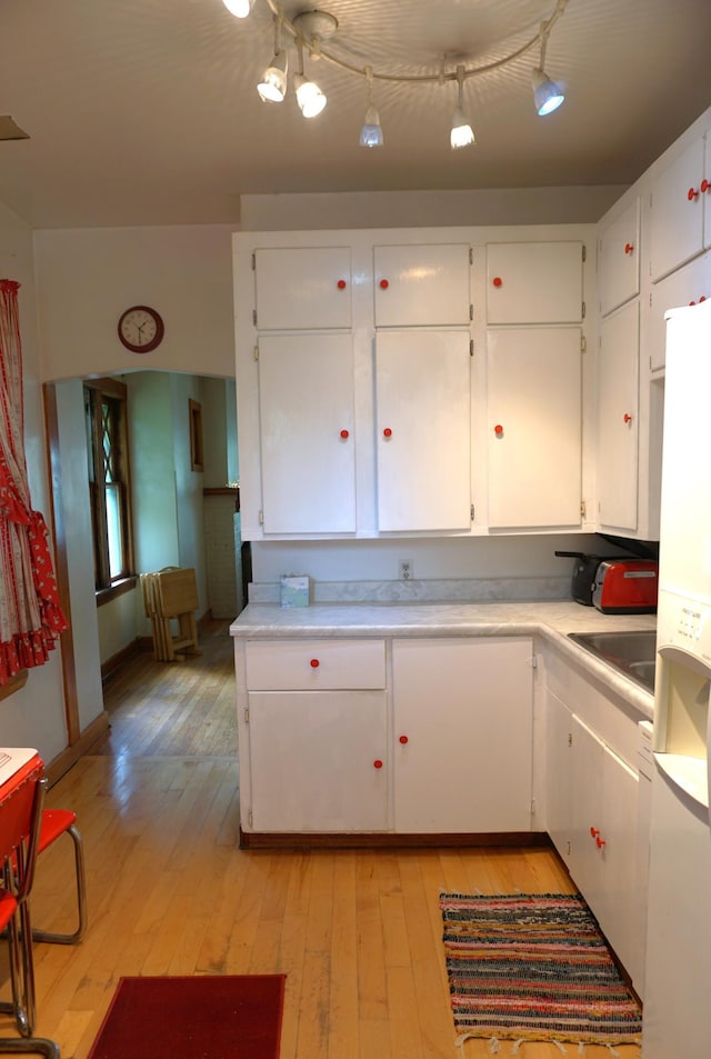1107 Edmund Ave, Saint Paul, MN 55104 - kitchen with light wood-style flooring, white cabinets, light countertops, and freestanding refrigerator