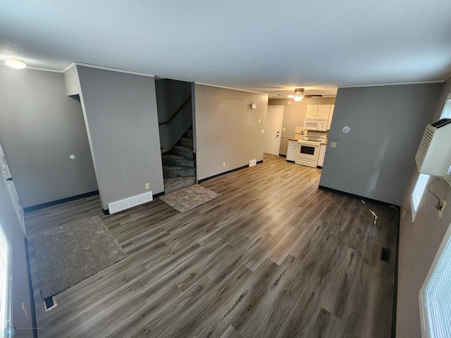 1033 27th St N, Fargo, ND 58102 - unfurnished living room featuring stairs, wood finished floors, baseboards, and crown molding