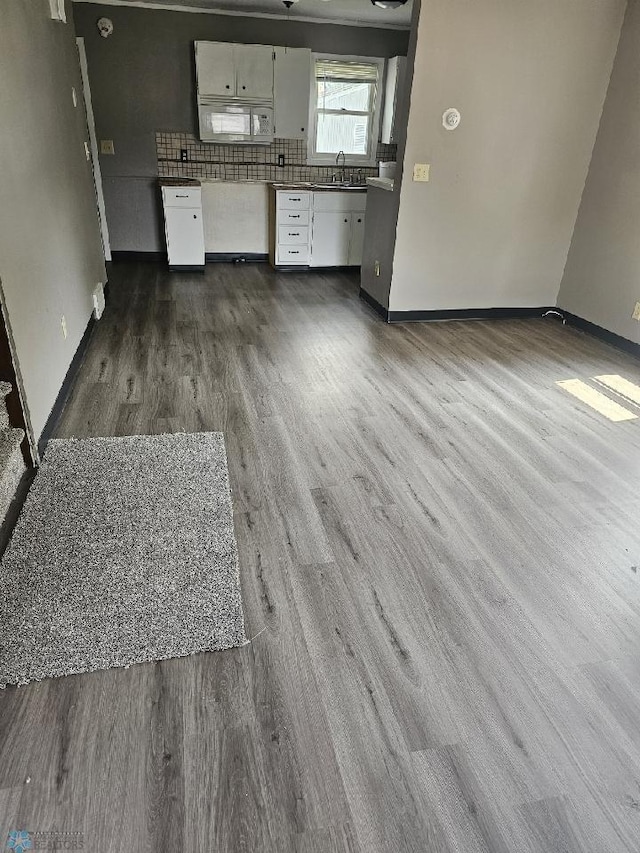 1033 27th St N, Fargo, ND 58102 - unfurnished living room with dark wood-style flooring, a sink, and baseboards