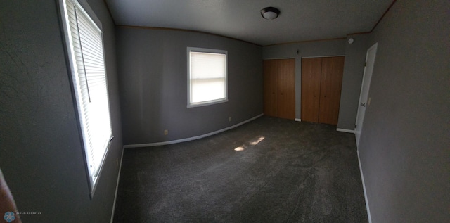 1033 27th St N, Fargo, ND 58102 - unfurnished bedroom featuring multiple closets, carpet floors, baseboards, and lofted ceiling