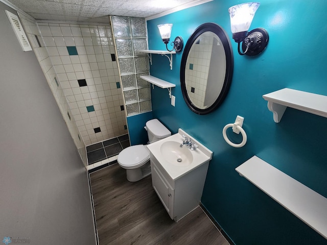 1033 27th St N, Fargo, ND 58102 - bathroom with toilet, wood finished floors, a tile shower, and vanity