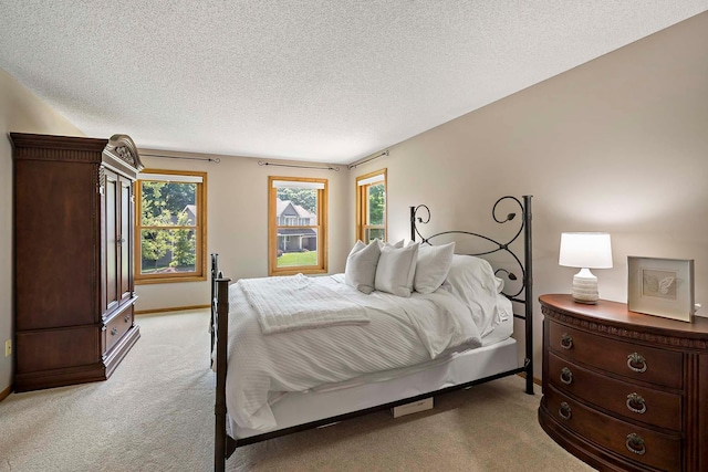 13545 Glasgow Ln, Apple Valley, MN 55124 - bedroom featuring light carpet, multiple windows, a textured ceiling, and baseboards