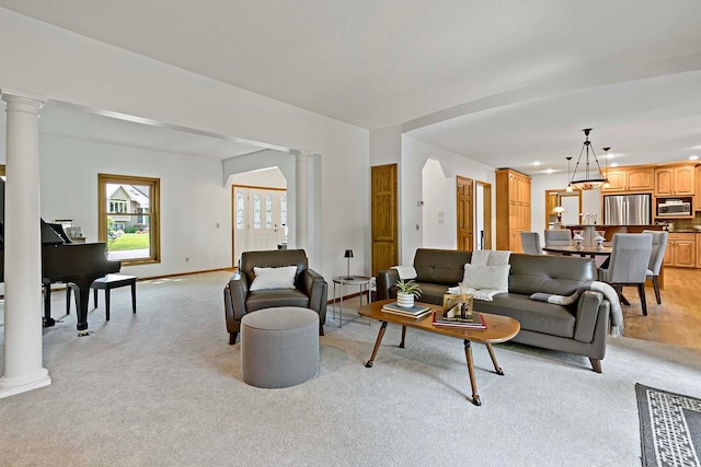 13545 Glasgow Ln, Apple Valley, MN 55124 - living room featuring ornate columns, light colored carpet, and baseboards
