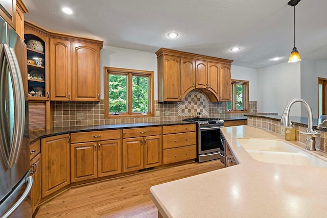 13545 Glasgow Ln, Apple Valley, MN 55124 - kitchen featuring stainless steel appliances, a sink, light wood-style floors, brown cabinets, and recessed lighting