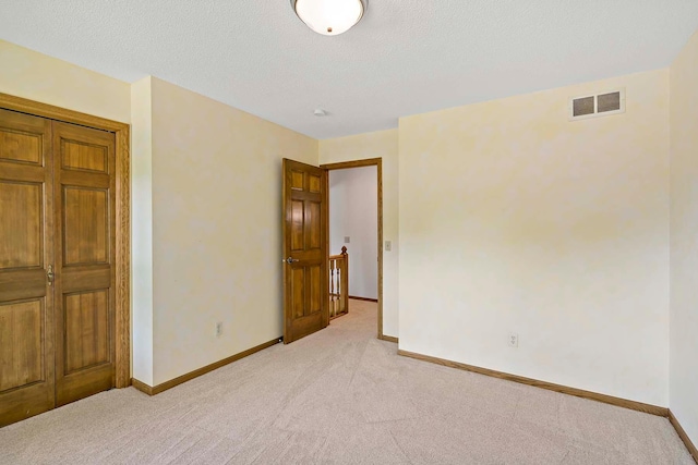 13545 Glasgow Ln, Apple Valley, MN 55124 - unfurnished bedroom featuring light carpet, baseboards, and a textured ceiling