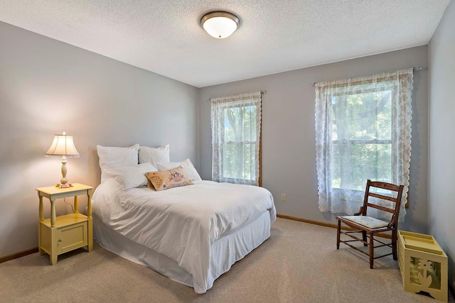 13545 Glasgow Ln, Apple Valley, MN 55124 - bedroom with light colored carpet, a textured ceiling, and baseboards