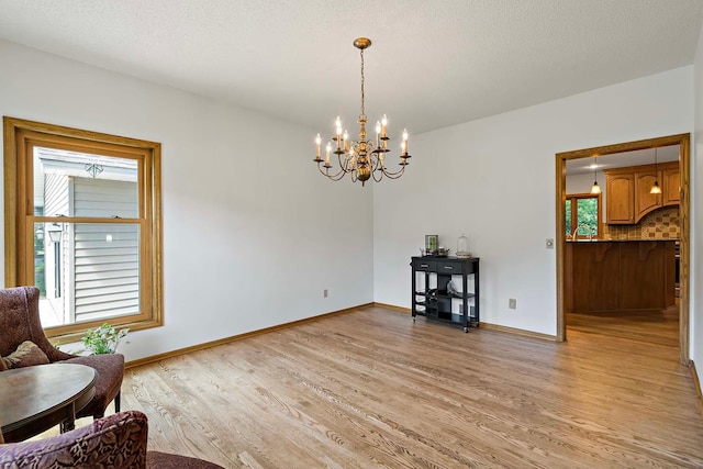 13545 Glasgow Ln, Apple Valley, MN 55124 - living area featuring light wood-style floors, a chandelier, and baseboards