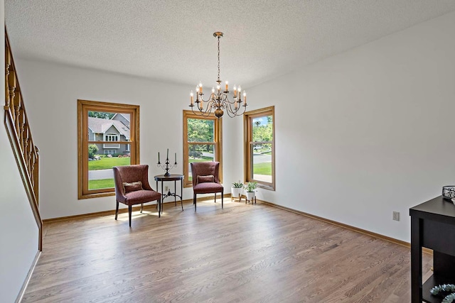 13545 Glasgow Ln, Apple Valley, MN 55124 - sitting room featuring a chandelier, wood finished floors, healthy amount of natural light, a textured ceiling, and baseboards