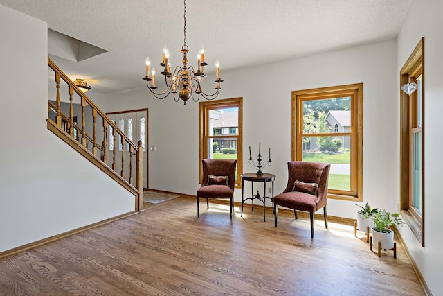 13545 Glasgow Ln, Apple Valley, MN 55124 - living area featuring wood finished floors, stairs, a chandelier, baseboards, and a textured ceiling