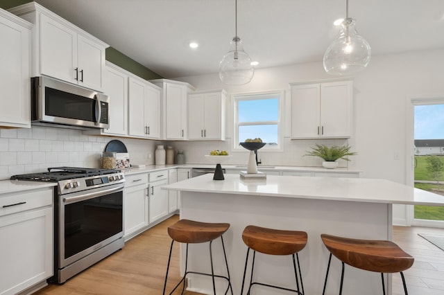 864 150th Ln NW, Andover, MN 55304 - kitchen featuring appliances with stainless steel finishes, a breakfast bar, white cabinetry, and recessed lighting