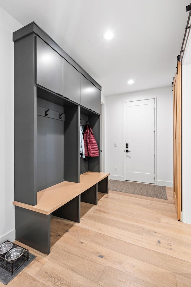 16216 Gleason Lake Rd, Minnetonka, MN 55391 - mudroom featuring a barn door, light wood-style flooring, recessed lighting, and baseboards