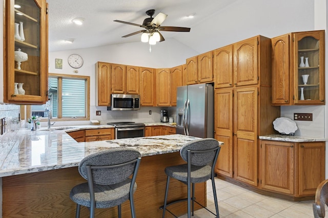 1378 Dunsmore Dr, Waconia, MN 55387 - kitchen featuring appliances with stainless steel finishes, a sink, a peninsula, light stone counters, and glass insert cabinets